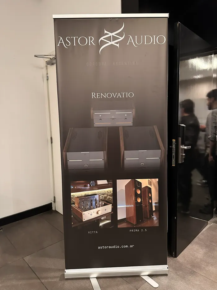 Banner de AstorAudio en la entrada de su sala en el Buenos Aires High-End Audio Show 2026, con el logo de la marca y equipos de su línea de fabricación propia